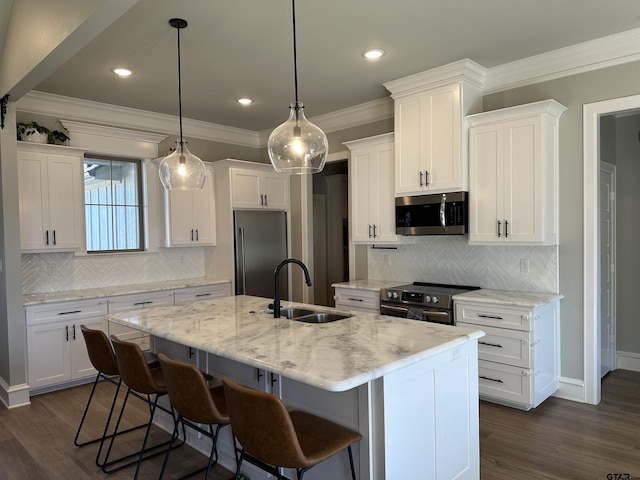 kitchen featuring an island with sink, a sink, appliances with stainless steel finishes, white cabinets, and crown molding