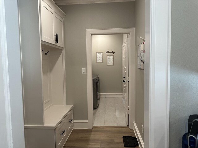 mudroom featuring washing machine and clothes dryer, dark wood-style floors, and baseboards