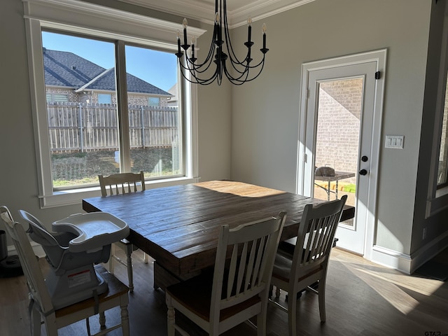 dining space with a healthy amount of sunlight, wood finished floors, and ornamental molding