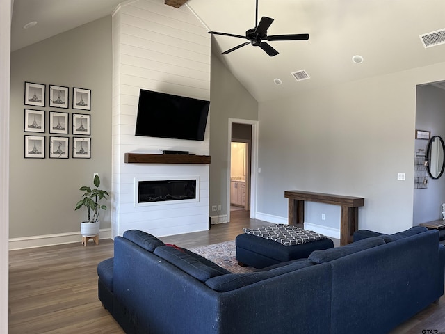 living area with wood finished floors, a fireplace, visible vents, and ceiling fan