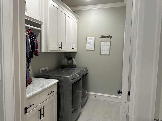 clothes washing area featuring crown molding, baseboards, washing machine and dryer, light tile patterned flooring, and cabinet space