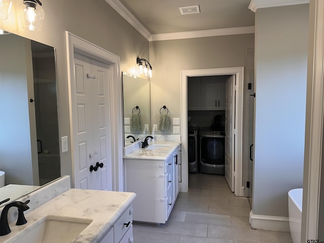 full bathroom featuring washer and clothes dryer, ornamental molding, visible vents, and a sink