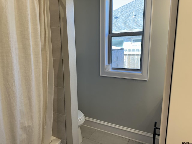 bathroom featuring tile patterned flooring, toilet, baseboards, and a shower with curtain