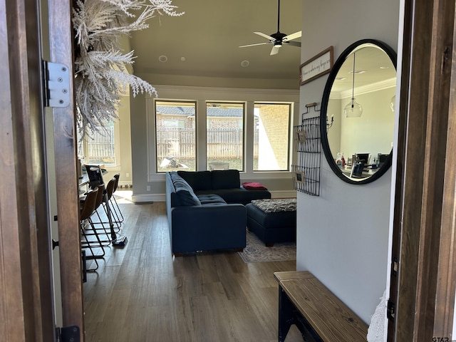 living area with ceiling fan, baseboards, and wood finished floors