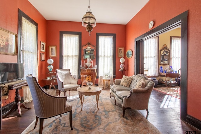 living area featuring a chandelier and hardwood / wood-style flooring