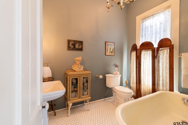 bathroom featuring a bathing tub, tile patterned flooring, and toilet