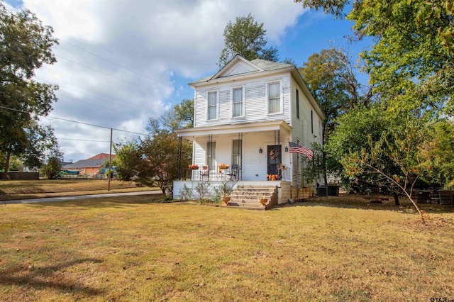 view of front of home with covered porch, cooling unit, and a front yard