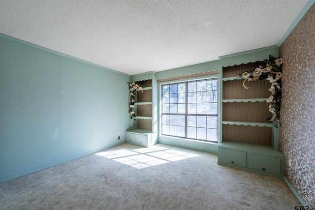 unfurnished room with a textured ceiling, light colored carpet, and crown molding