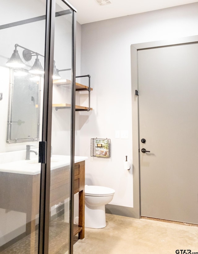 bathroom featuring vanity, toilet, and an enclosed shower