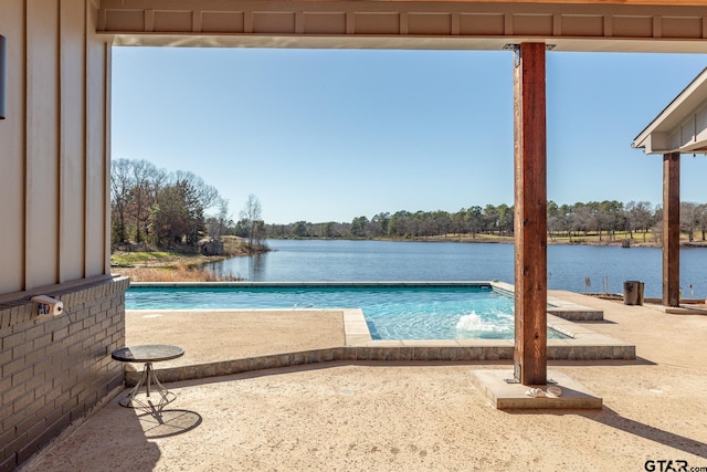 view of swimming pool with a water view and a patio area