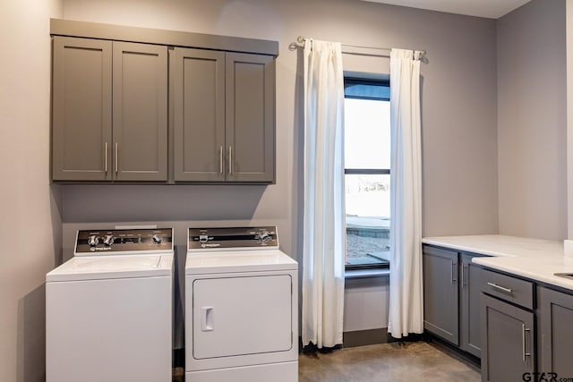 washroom with cabinets and washer and dryer