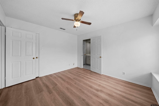 unfurnished bedroom with a textured ceiling, light hardwood / wood-style floors, and ceiling fan