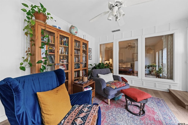 living area with hardwood / wood-style flooring and ceiling fan