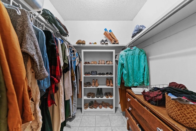 walk in closet with light tile patterned floors