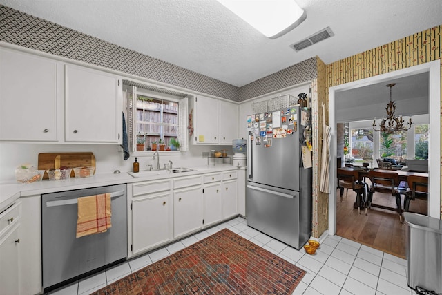 kitchen featuring white cabinetry, plenty of natural light, stainless steel appliances, and sink