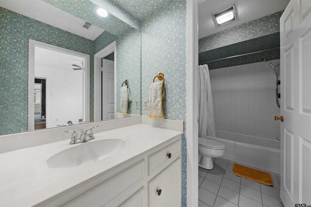 full bathroom with tile patterned flooring, a textured ceiling, toilet, shower / bath combo with shower curtain, and vanity