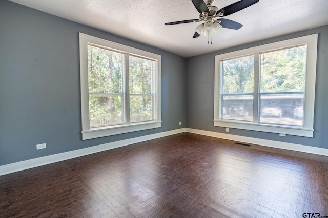 spare room with dark hardwood / wood-style flooring, a textured ceiling, ceiling fan, and plenty of natural light