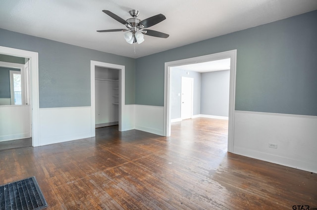 unfurnished bedroom featuring ceiling fan, dark hardwood / wood-style floors, and a closet