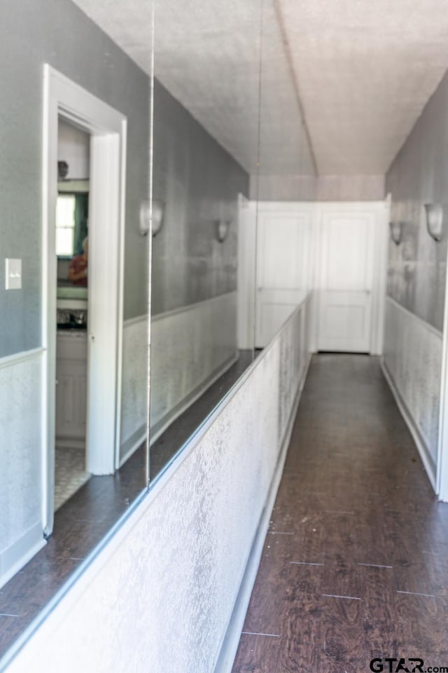 corridor with dark hardwood / wood-style flooring