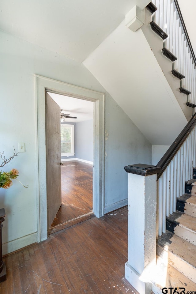 stairs with hardwood / wood-style floors and vaulted ceiling