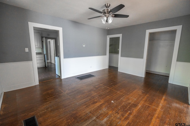 unfurnished bedroom featuring dark hardwood / wood-style floors, ceiling fan, and a closet