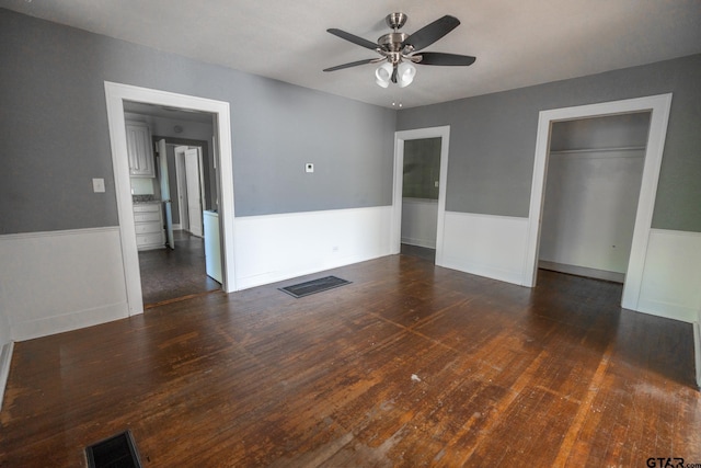 701 W Houston St, Tyler, TX 75702 - unfurnished bedroom with wainscoting, wood finished floors, a closet, and a ceiling fan