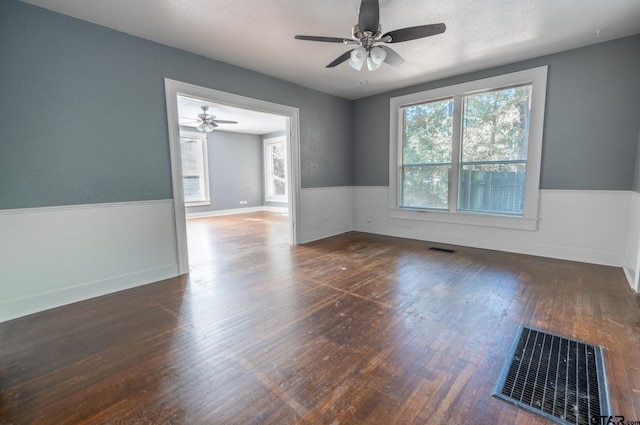 spare room with ceiling fan, a textured ceiling, and dark hardwood / wood-style flooring