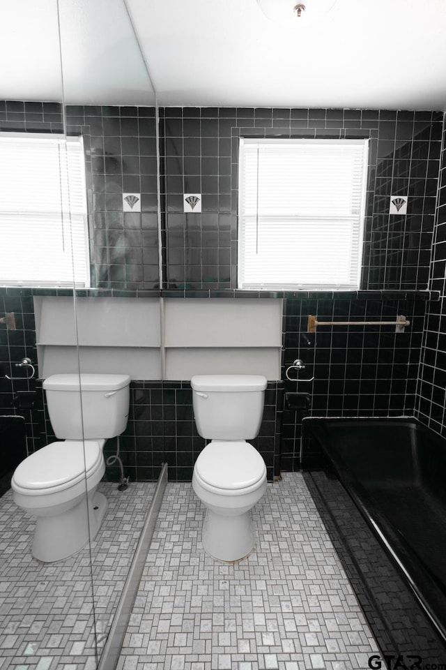 bathroom featuring tile walls and toilet