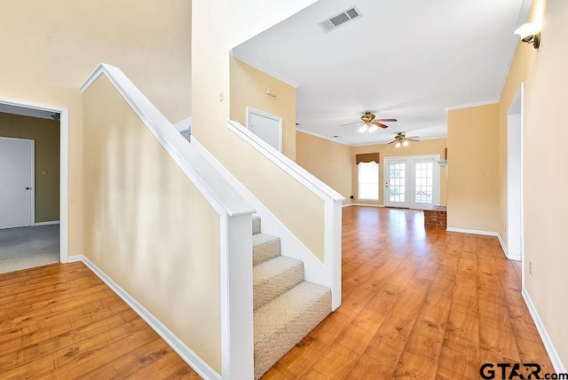 stairway featuring hardwood / wood-style flooring, crown molding, and ceiling fan