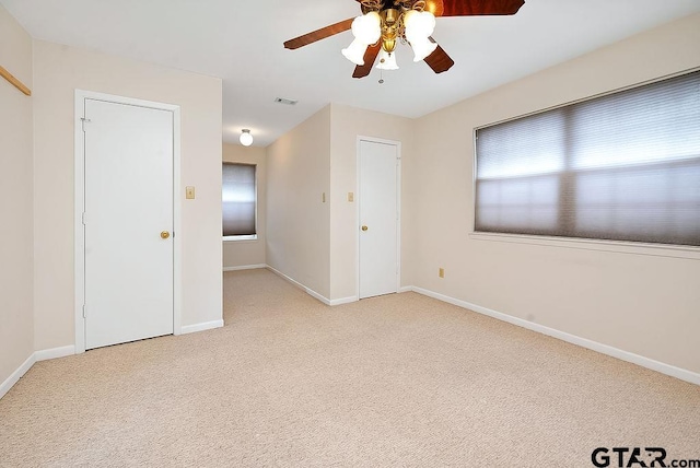 empty room with ceiling fan and light colored carpet