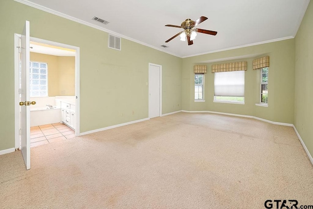 carpeted spare room featuring ceiling fan, plenty of natural light, and crown molding