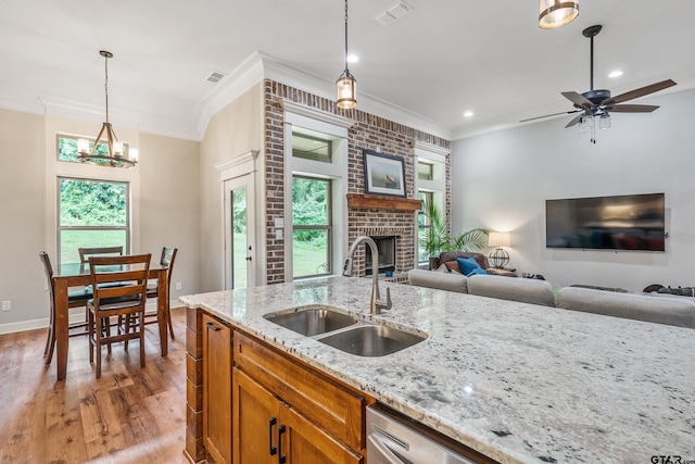 20851 Lakeview Dr, Flint, TX 75762 - kitchen featuring ornamental molding, brown cabinetry, healthy amount of natural light, a fireplace, and light wood-style flooring
