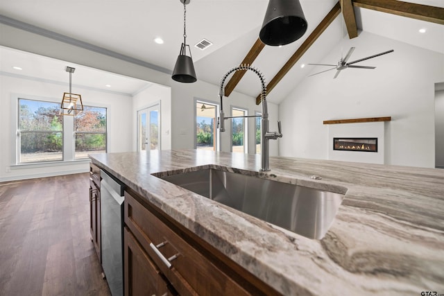 kitchen with light stone countertops, dishwasher, sink, vaulted ceiling with beams, and dark hardwood / wood-style floors