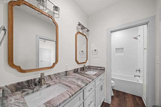 full bathroom featuring hardwood / wood-style flooring, shower / washtub combination, vanity, and toilet