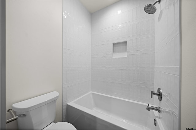 bathroom featuring toilet and tiled shower / bath