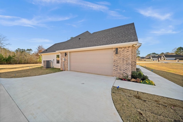 view of side of home featuring central AC unit and a garage