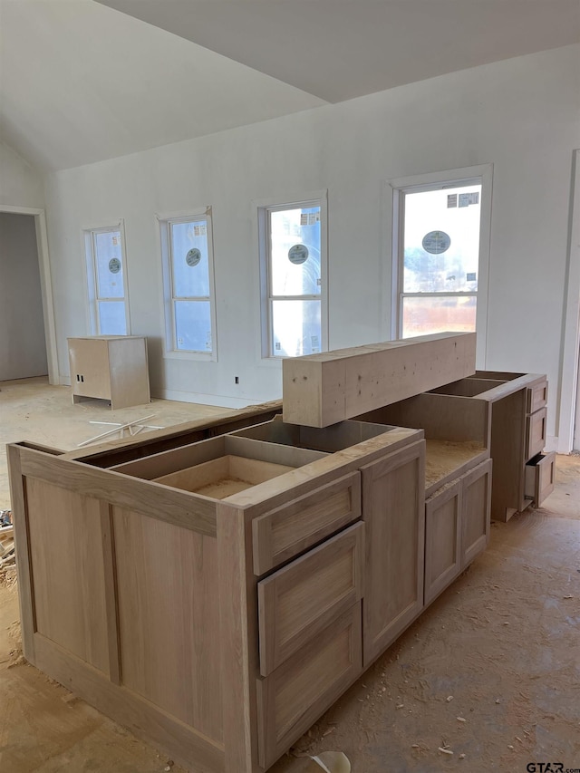 kitchen featuring lofted ceiling and light brown cabinetry