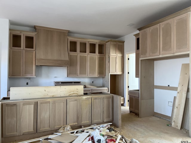 kitchen with light brown cabinets and premium range hood