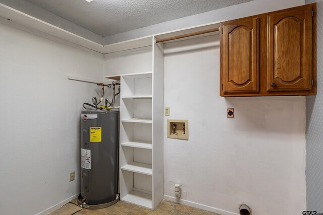 clothes washing area with hookup for a washing machine, a textured ceiling, cabinets, electric dryer hookup, and electric water heater