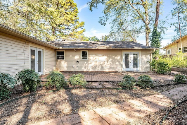 rear view of property featuring french doors and a wooden deck