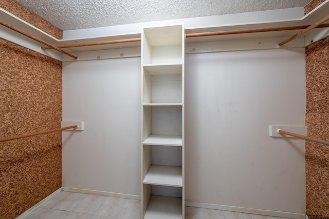 walk in closet with light tile patterned flooring