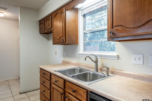 kitchen with sink, light tile patterned floors, a healthy amount of sunlight, and a textured ceiling