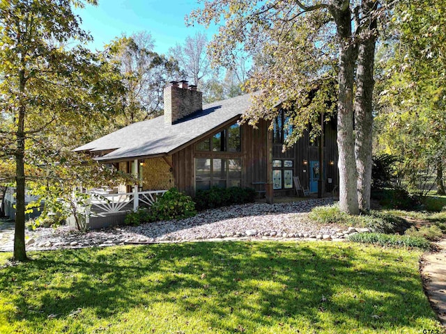 rear view of house featuring a yard and a chimney