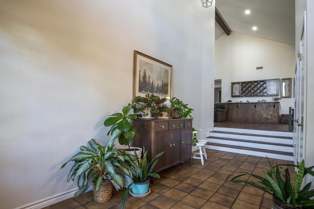 interior space with beam ceiling, high vaulted ceiling, and dark tile patterned flooring