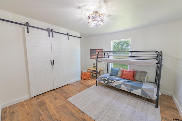 bedroom featuring a barn door and wood-type flooring