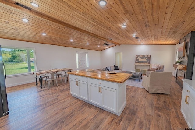 kitchen featuring wood-type flooring, butcher block counters, vaulted ceiling, white cabinets, and wooden ceiling