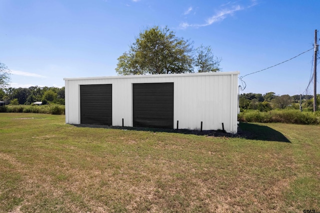 view of outdoor structure with a garage and a lawn