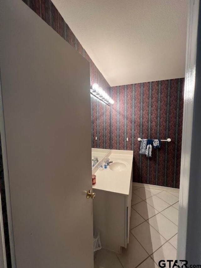 bathroom featuring tile patterned floors, vanity, and wallpapered walls