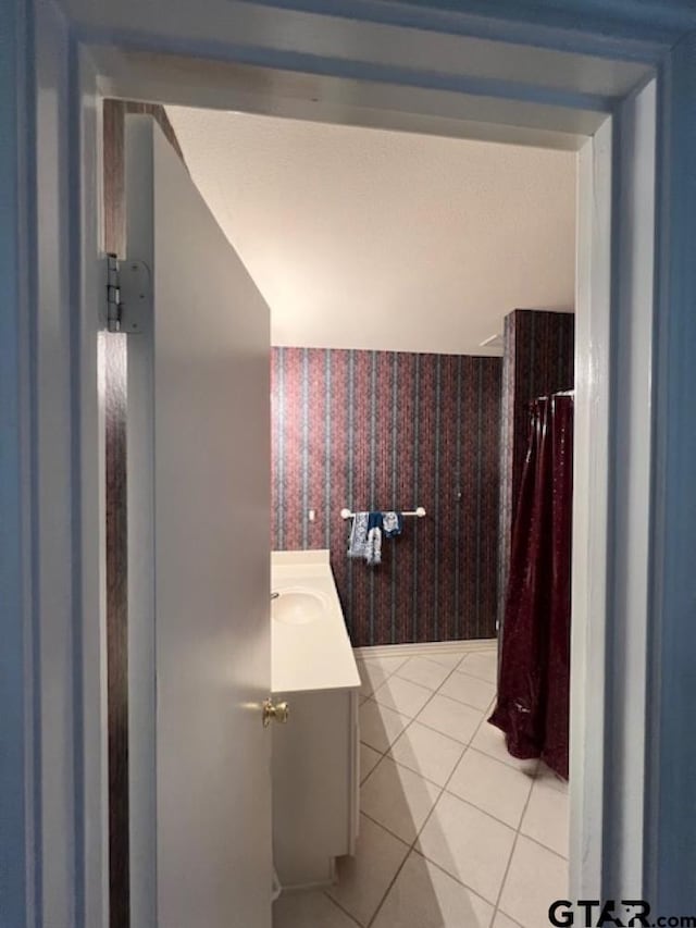 bathroom featuring tile patterned floors, wallpapered walls, vanity, and a shower with curtain