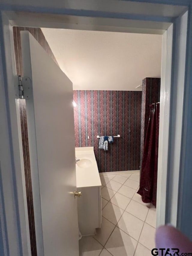 bathroom with vanity, tile patterned flooring, and wallpapered walls